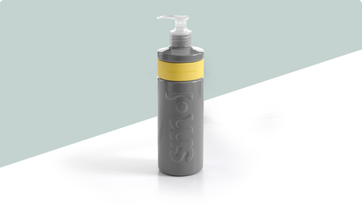 smol's grey and yellow fabric softener bottle on a countertop